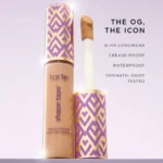 Tarte shape tape full-coverage concealer - 12B with a purple and gold geometric cap design, featuring a doe-foot applicator. Text highlights 16-hour wear and waterproof qualities.