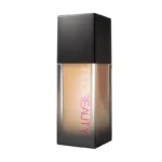 Huda Beauty Faux Filter Foundation in light beige color, shade Cashew 140G, displayed in a sleek bottle.